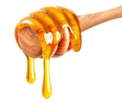 a honey dripping from a wooden spoon