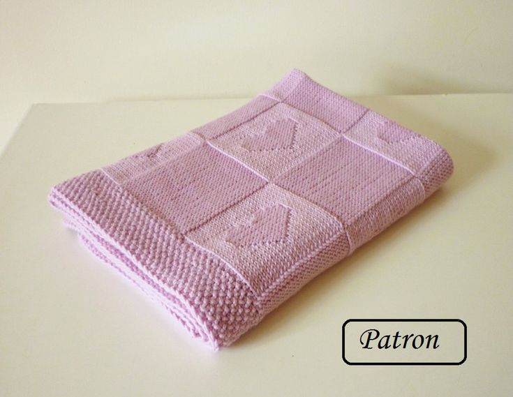 a pink knitted blanket sitting on top of a table