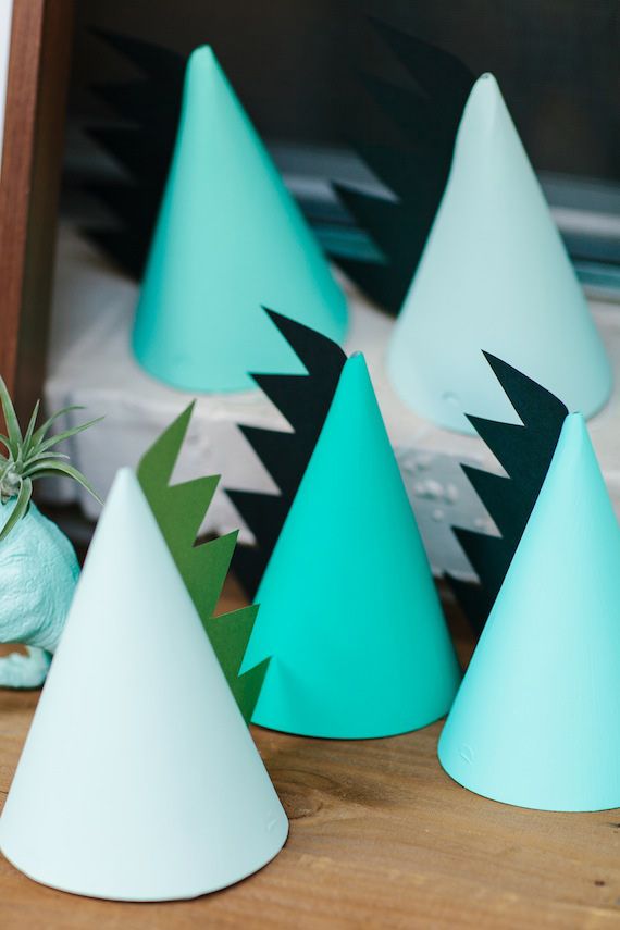 several blue and white party hats sitting on top of a wooden table next to an air plant