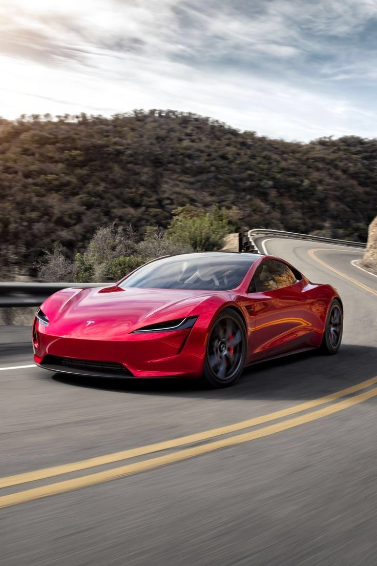 a red sports car driving down the road