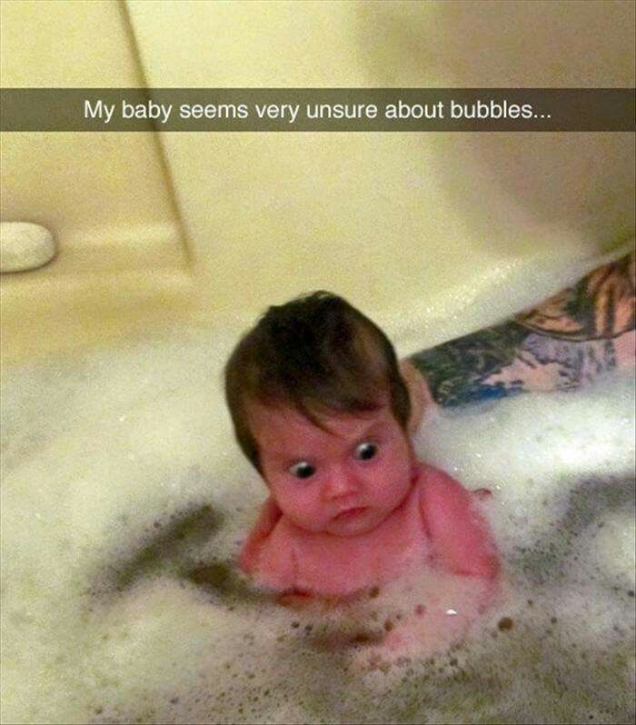 a baby sitting in a bathtub with the caption'my baby seems very unature about bubbles '