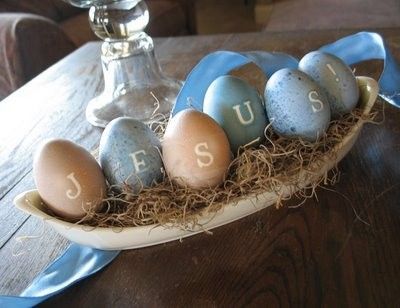 eggs in a bowl with the word jesus painted on them, sitting on a table