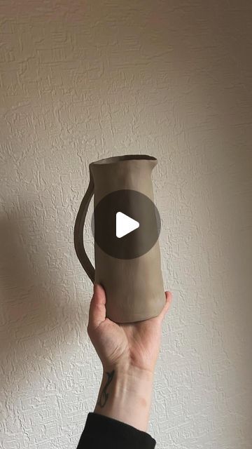 a person holding up a cup with a video on the bottom and an arrow in the middle