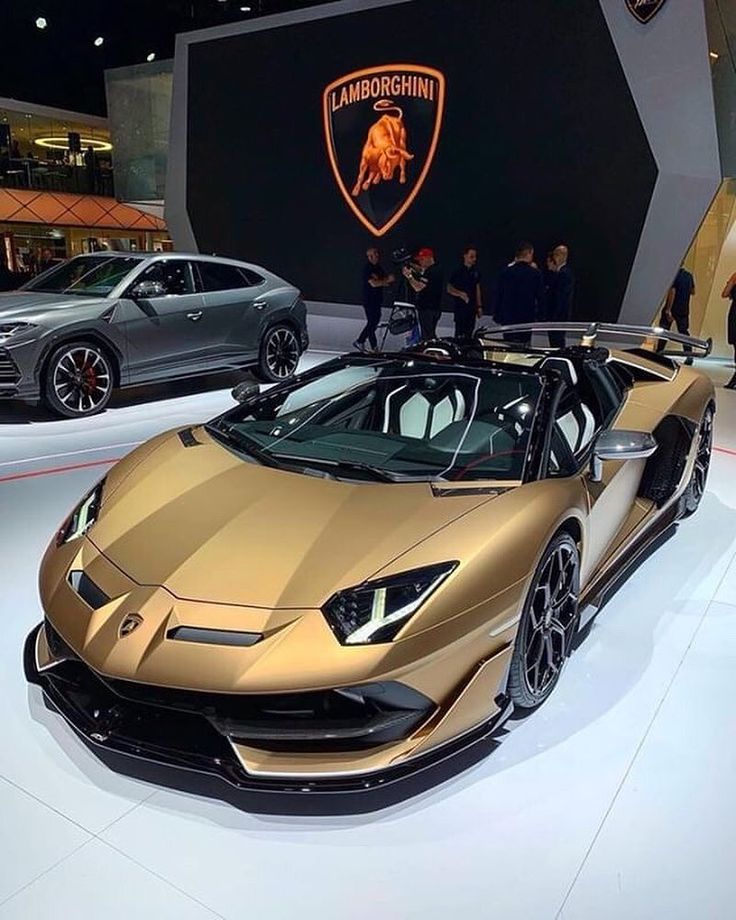 a gold lamb car on display at an auto show