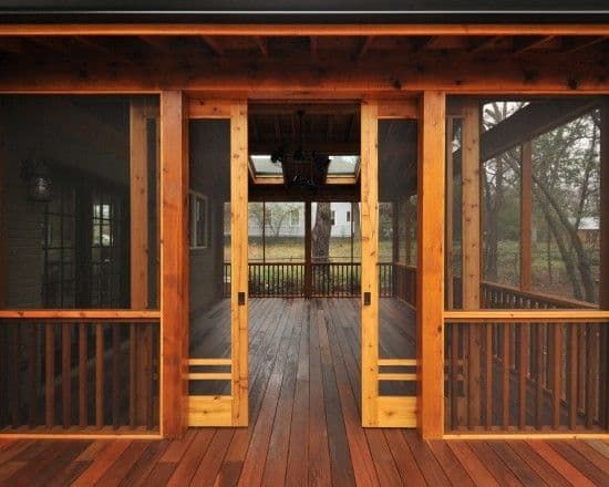 an open porch with wooden floors and windows