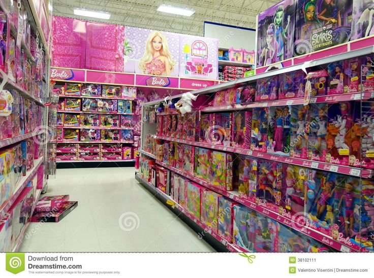 an aisle in a toy store filled with barbie dolls and other toys for sale on the shelves