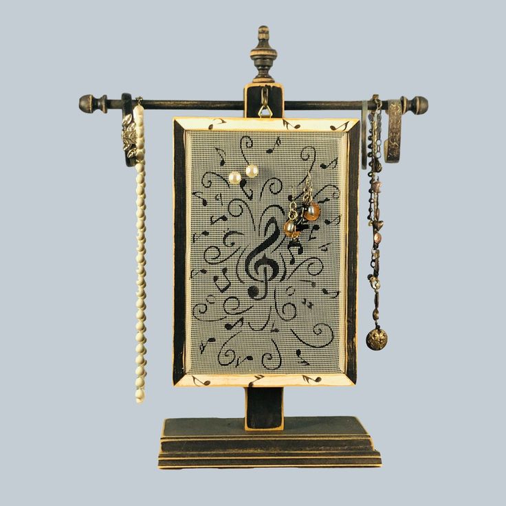 an ornate clock with music notes on it's face and chains hanging from the sides