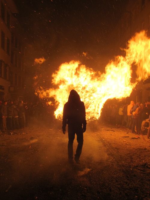 a person standing in front of a large fire with flames coming out of the back