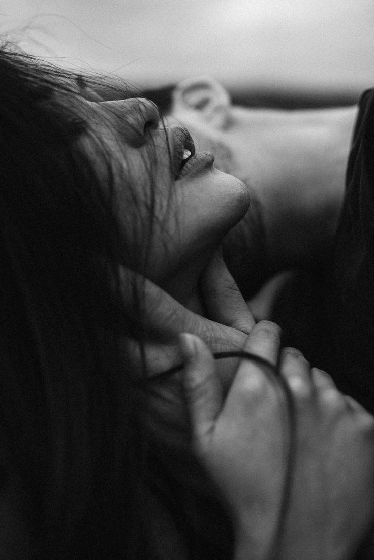 a woman laying down with her head on the hand of another person's shoulder