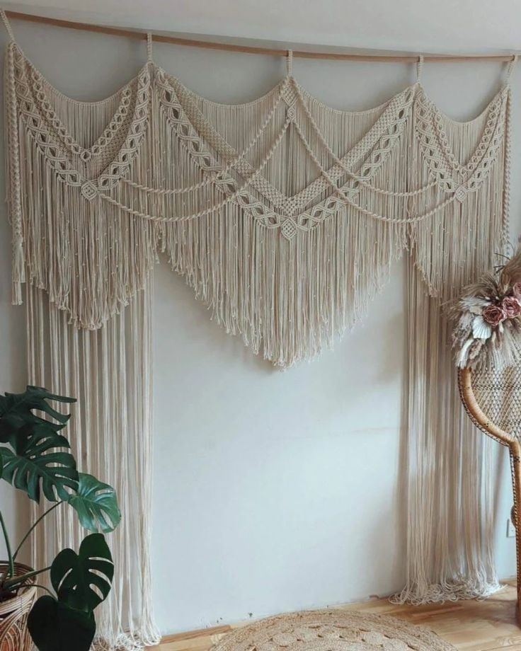 a chair sitting in front of a window with macrame hanging from it's sides