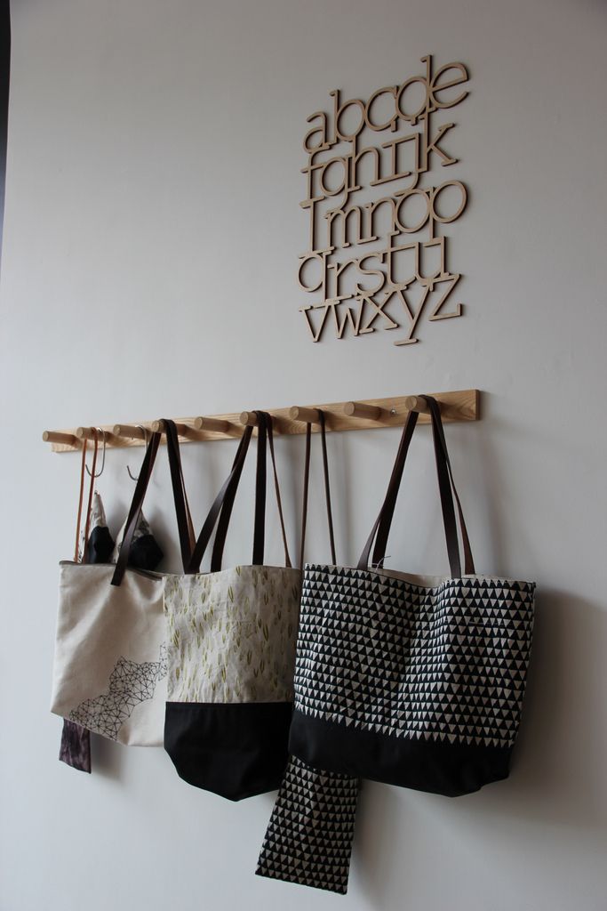 three purses hanging from hooks on a wall