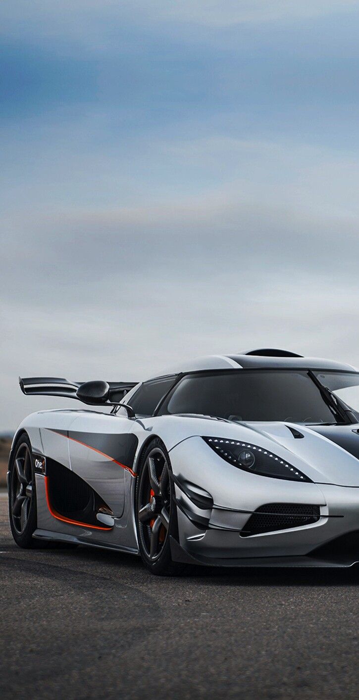 a silver and orange sports car on the road