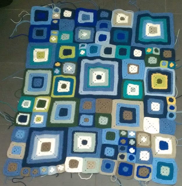 a blue and green quilt with square designs on the bottom, along with squares in different colors