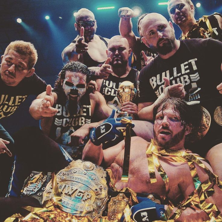 the wrestlers are posing for a group photo with their belts around their necks and holding trophies