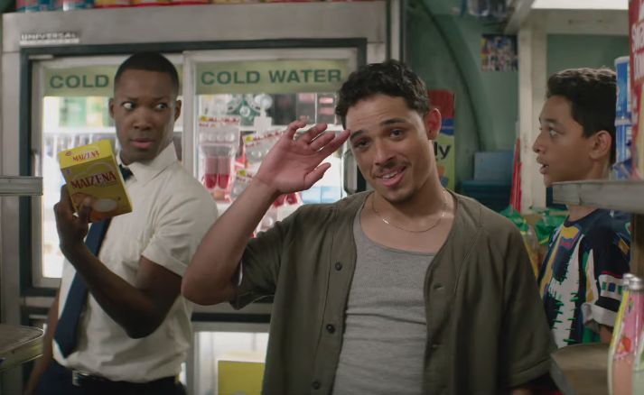 two men are standing in a store and one man is holding something up to his ear