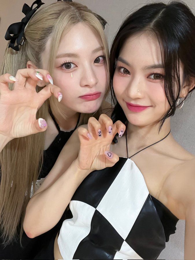 two young women posing for the camera with their hands painted white and black checkered