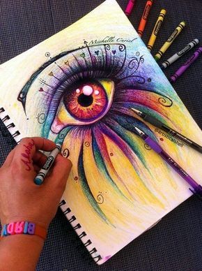 a drawing of an eye with colored pencils on the table next to some markers