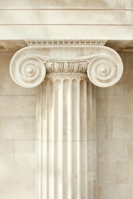 an old building with columns and a clock on the wall