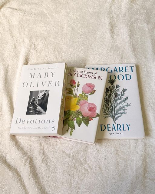 three paperback books laying on top of a bed