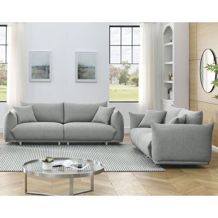 a living room with two couches and a coffee table in front of large windows