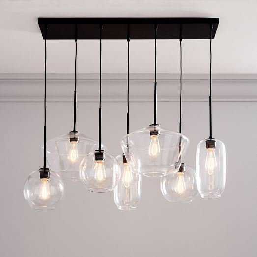 a bunch of lights that are hanging from a ceiling fixture in a room with white walls