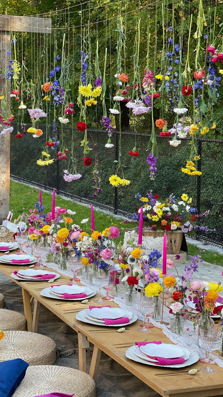 a long table is set with flowers and candles for an outdoor dinner or party event