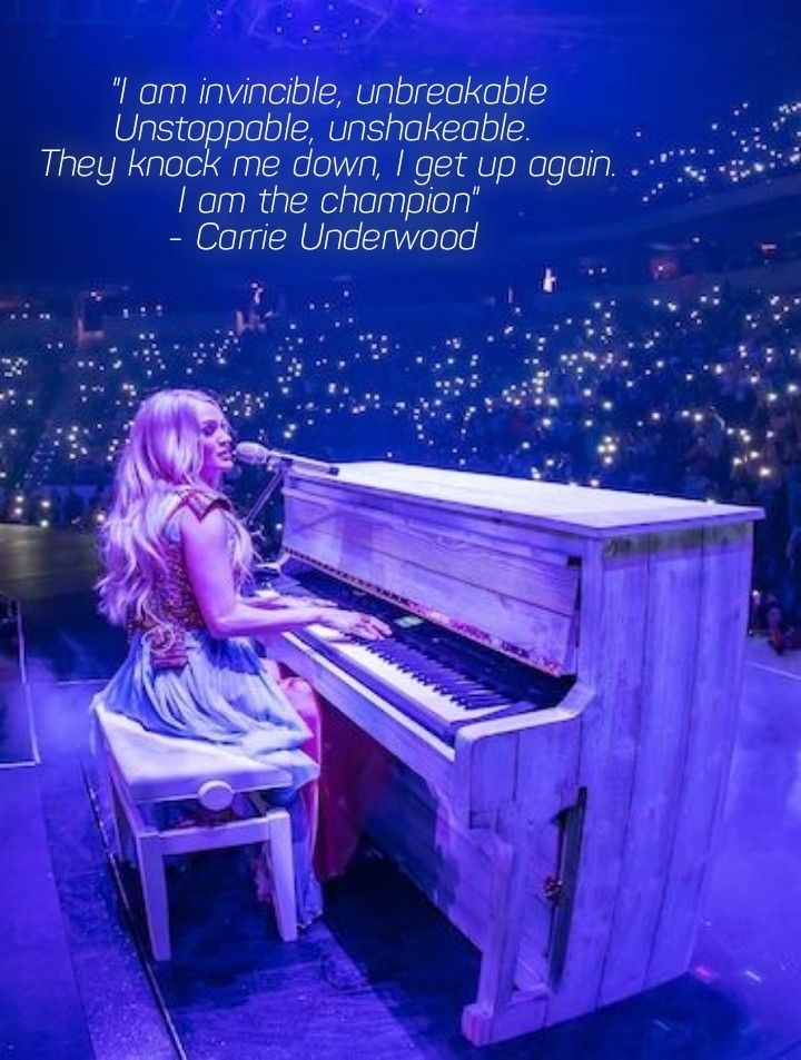 a woman sitting at a piano in front of a stage with lights on the ceiling