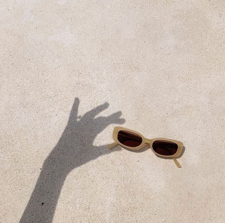 the shadow of a person's hand and sunglasses