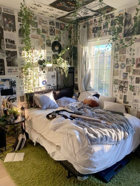 an unmade bed in a room with many pictures on the wall and green carpet