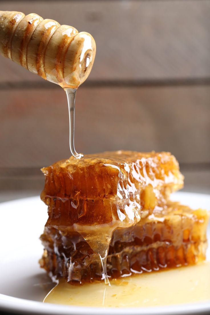 a piece of honey is being drizzled with honey on a white plate