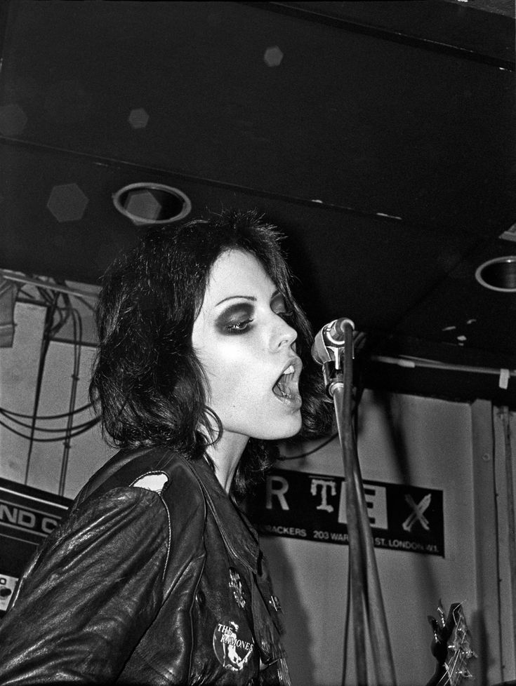 black and white photograph of a woman singing into a microphone