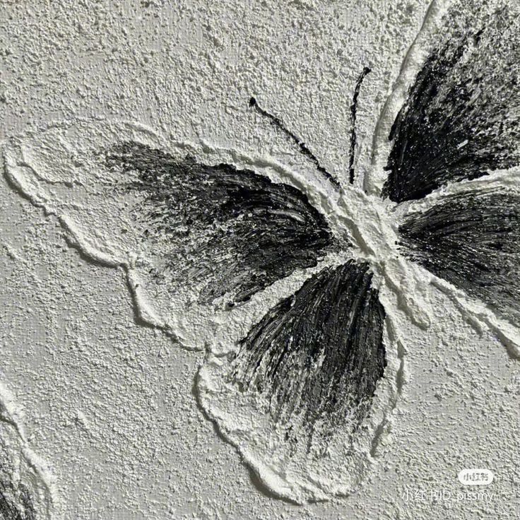 a black and white photo of a butterfly on the wall with some dirt around it
