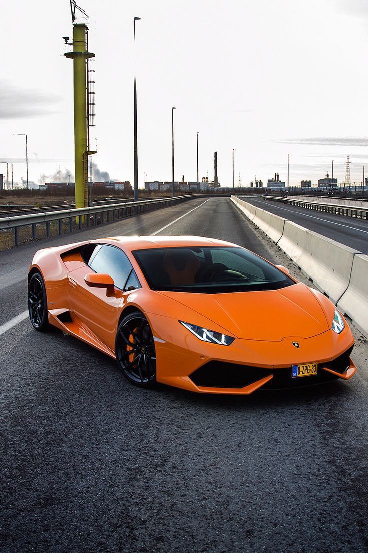 an orange sports car driving down the road