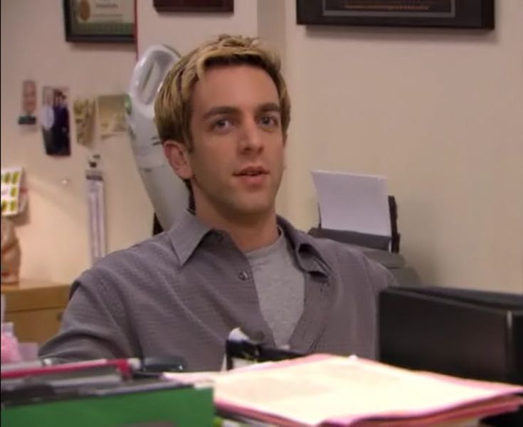 a man sitting at a desk with a computer in front of him and an office chair behind him