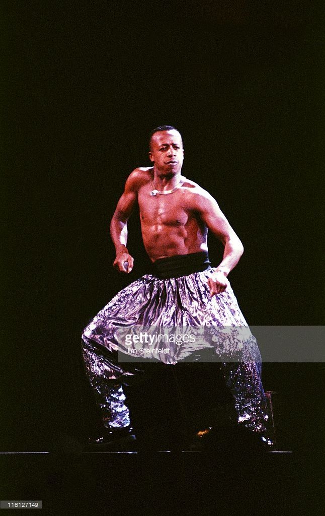 a man standing on top of a stage with his hands in his pockets and shirtless torso