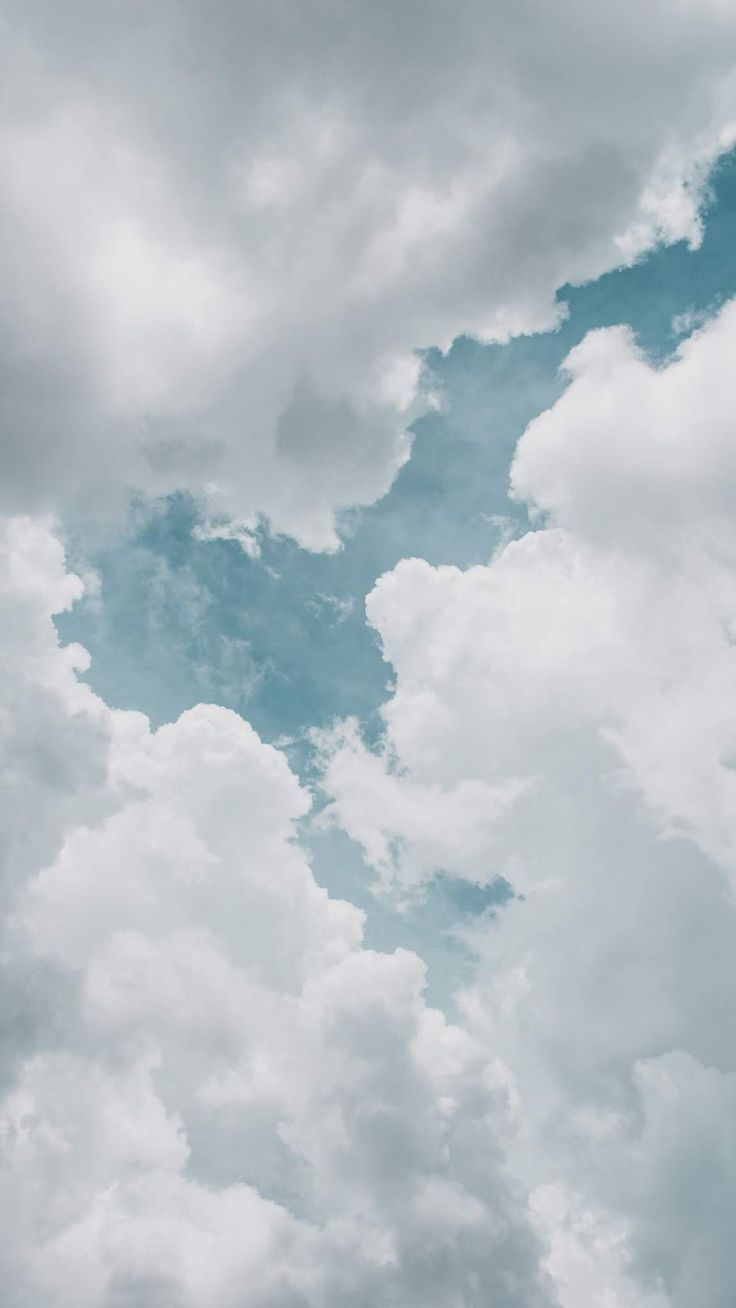 an airplane is flying through the cloudy sky