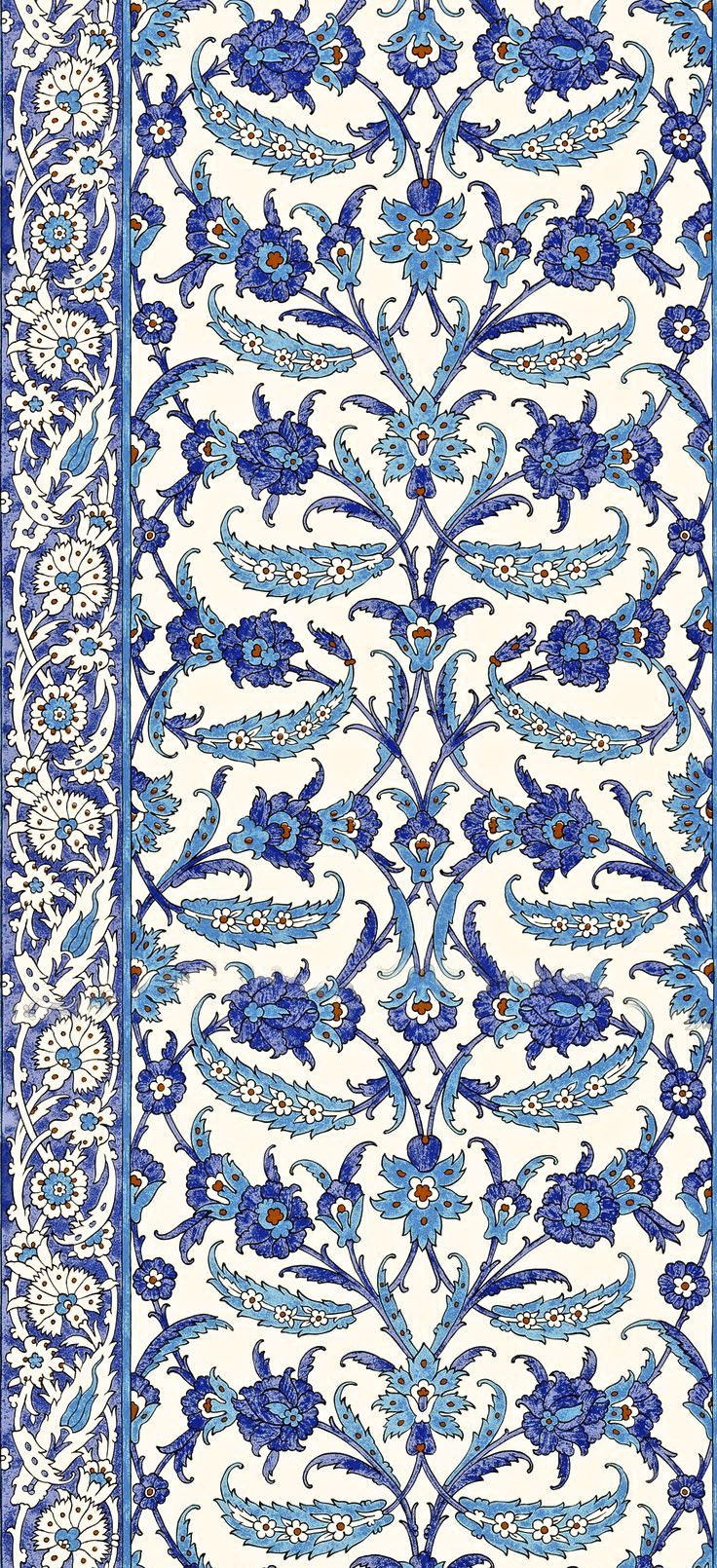 an intricately designed rug with blue and white designs on the border, in front of a