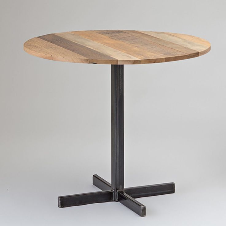 a round wooden table sitting on top of a metal base