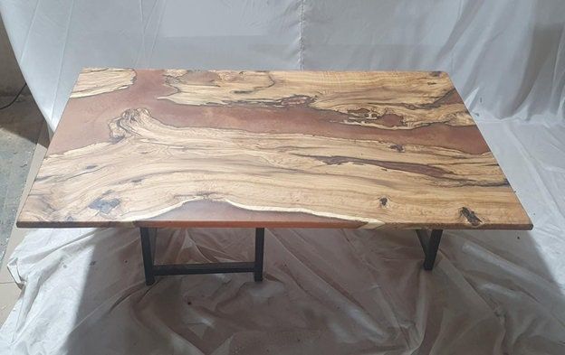 a wooden table sitting on top of a white sheet