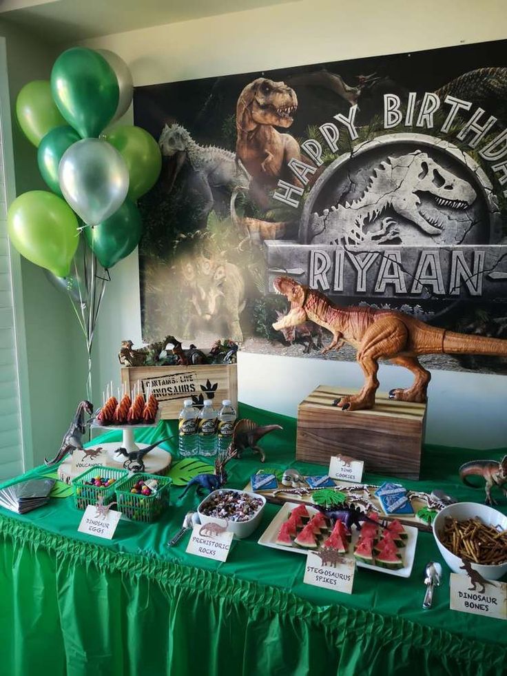 a dinosaur themed birthday party with balloons and food