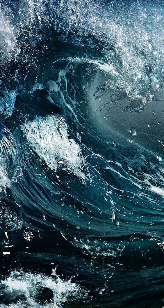 an ocean wave is breaking and it looks like they are in the middle of water