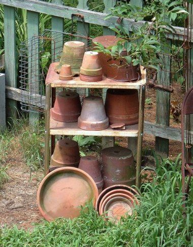 pots and pans are stacked on a shelf outside