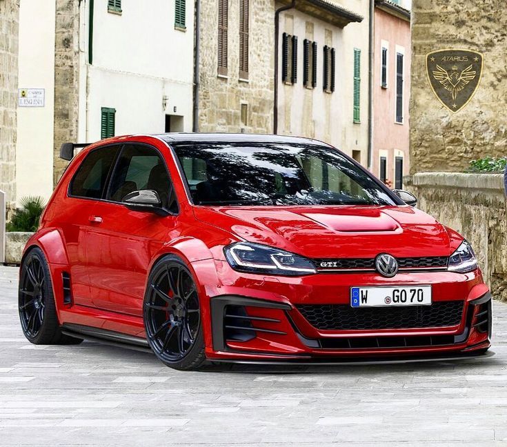 a red vw golf gti parked in front of an old stone building with green shutters