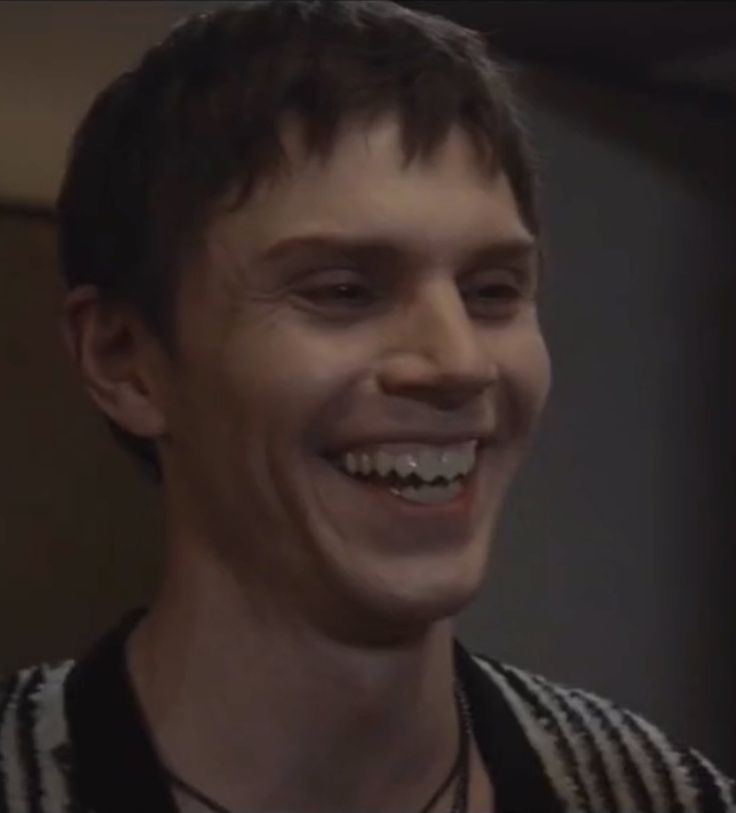 a young man with braces smiles at the camera