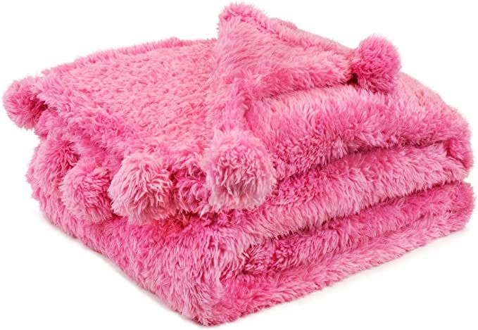 a pink teddy bear blanket folded on top of each other