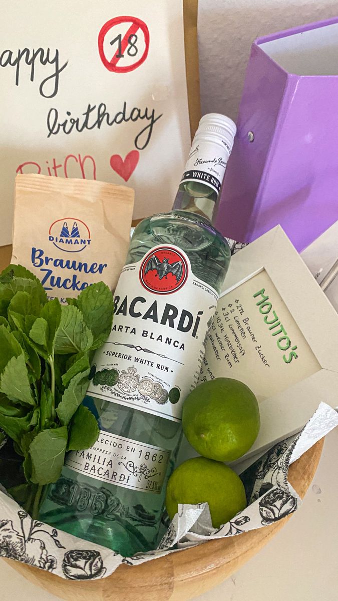 a basket filled with liquor, limes and other items next to a sign that says happy birthday