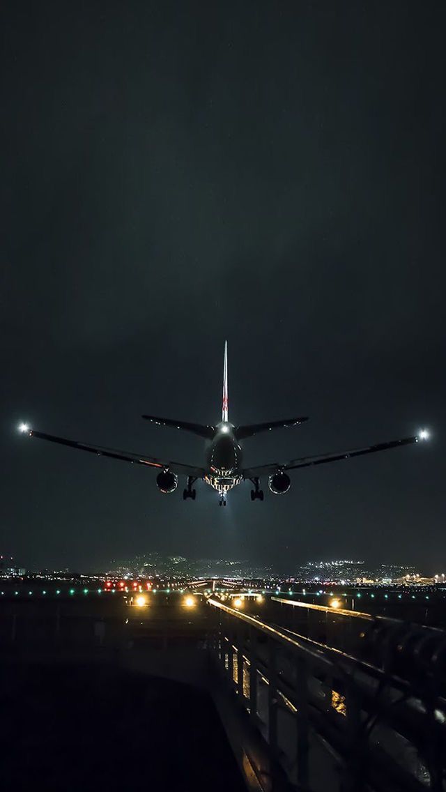 an airplane taking off from the runway at night