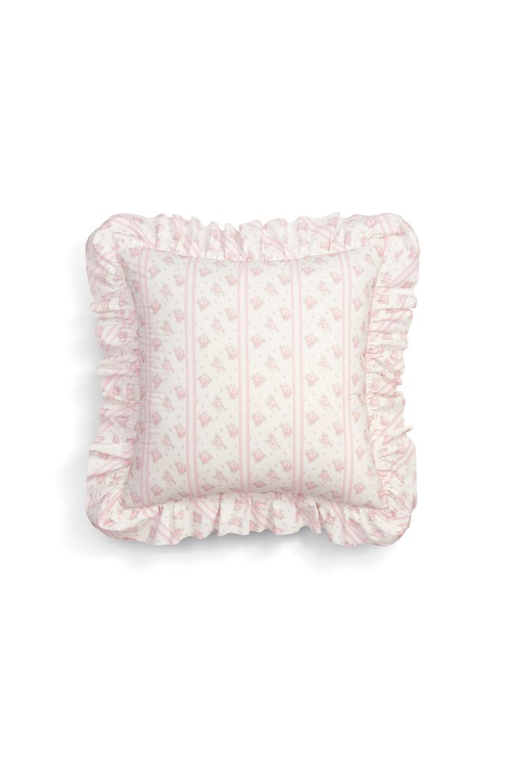 a pink and white pillow with ruffles on the bottom, in front of a white background