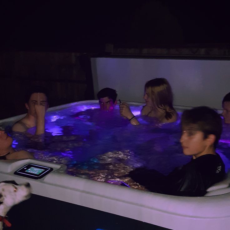 several people are in an indoor hot tub at night