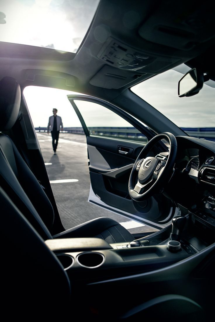 the interior of a car is shown with sun shining through the windshield and man walking in the distance